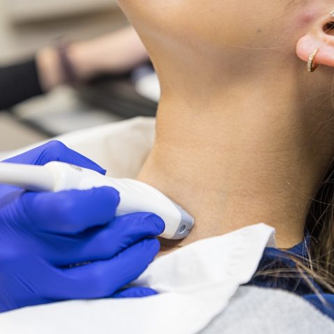 Patient receiving ultrasound on the throat.